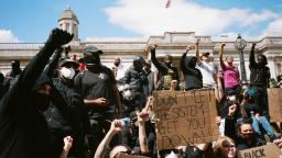 a crowd of people raising their fists at a black lives matter protest